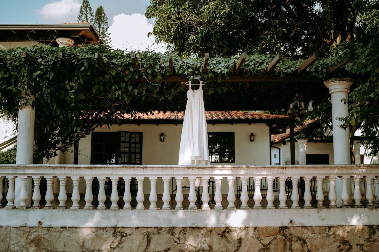 Finding Home in Paraguay: Our Housing Journey & How We Can Help You Find Yours 🏠🇵🇾 A white dress hanging on a leafy patio in Mariano Roque Alonso, Paraguay.